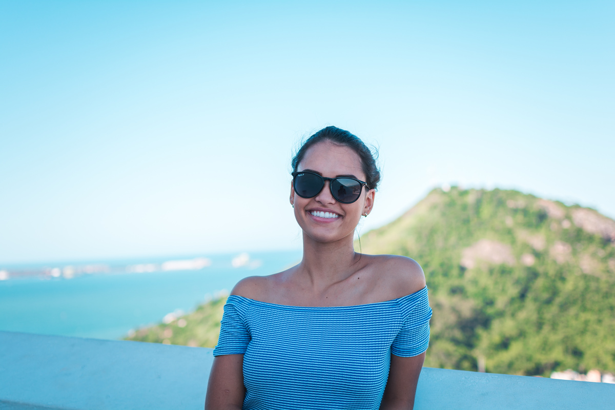 Smiling Woman Wearing Grey Striped Off-shoulder Top And Black Sunglasses